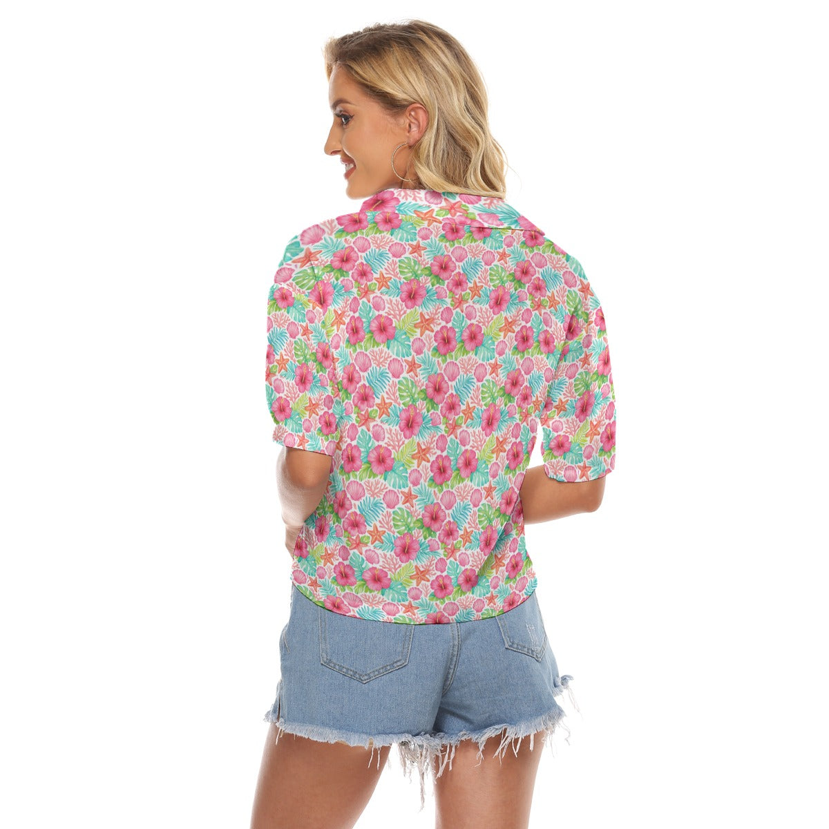 Woman wearing a colorful floral shirt and denim shorts on a white background